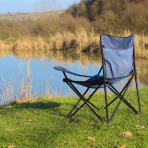 Gölün yanında duran kamp sandalyesi