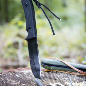 Several survival and bushcraft tools on a tree stump